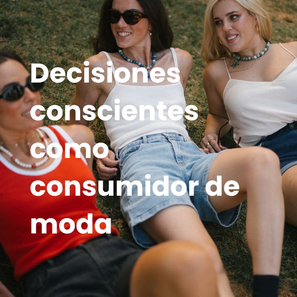 grupo de 3 amigas sentadas en el césped, todas visten pantalones cortos y dos de ellas llevan gafas de sol